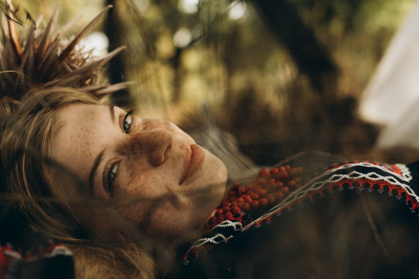 A woman lying in the grass, smiling and relaxed