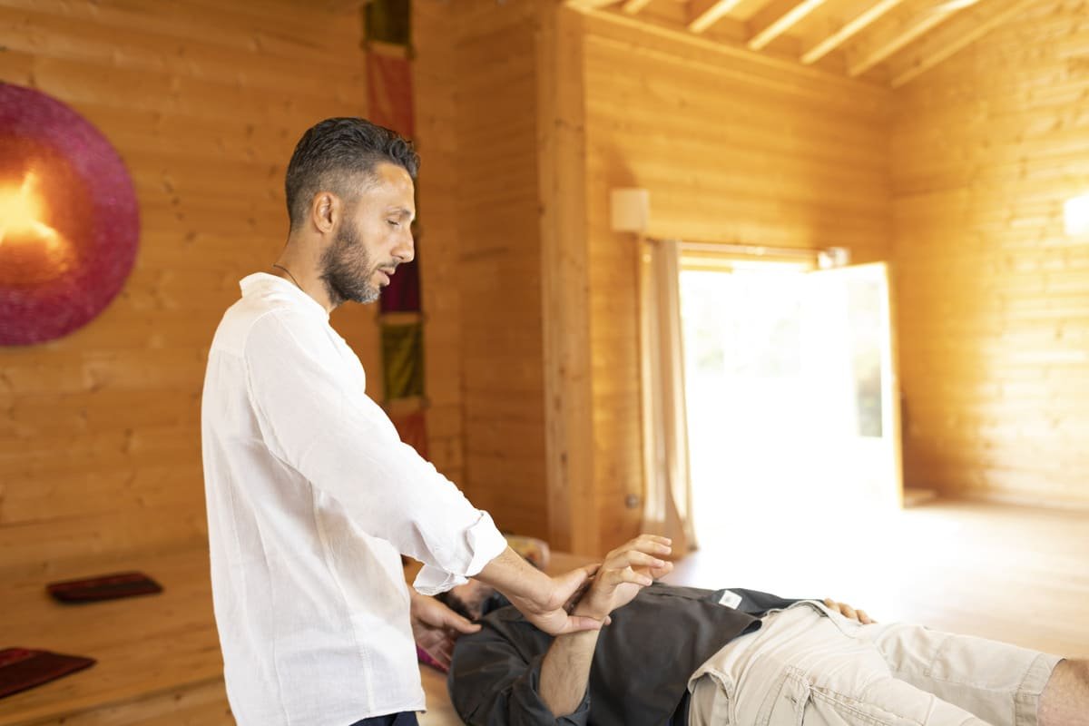 Riccardo guiding a participant lying on a mat during a session